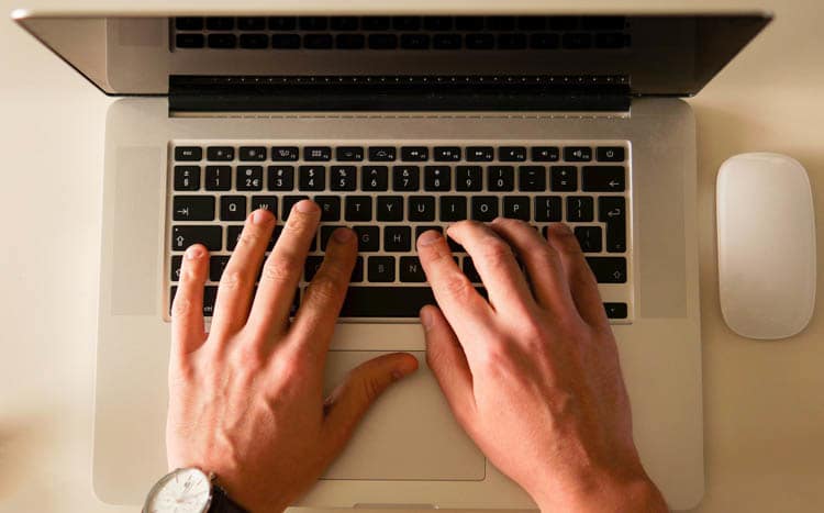Man is typing on a laptop keyboard