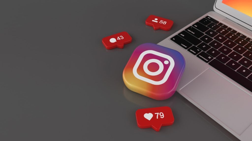 Red balloons with the followers, likes, comments icons one instagram badge near laptop